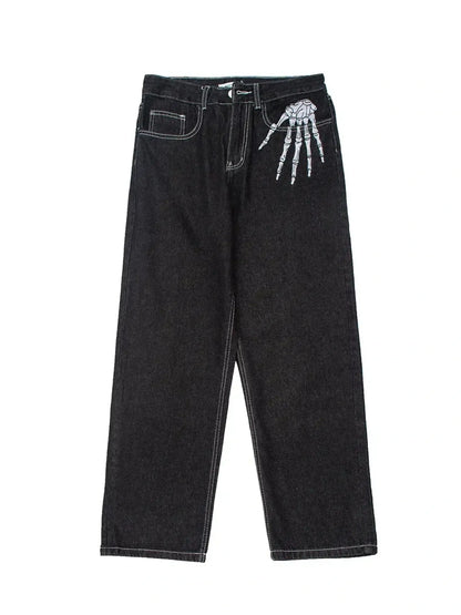 Men's black straight leg jeans with a white skeleton hand embroidered on the right hip.