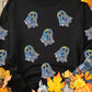Black long-sleeve sweatshirt with holographic ghost graphics.