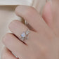 A silver bat ring with a moonstone gem is worn on a finger.