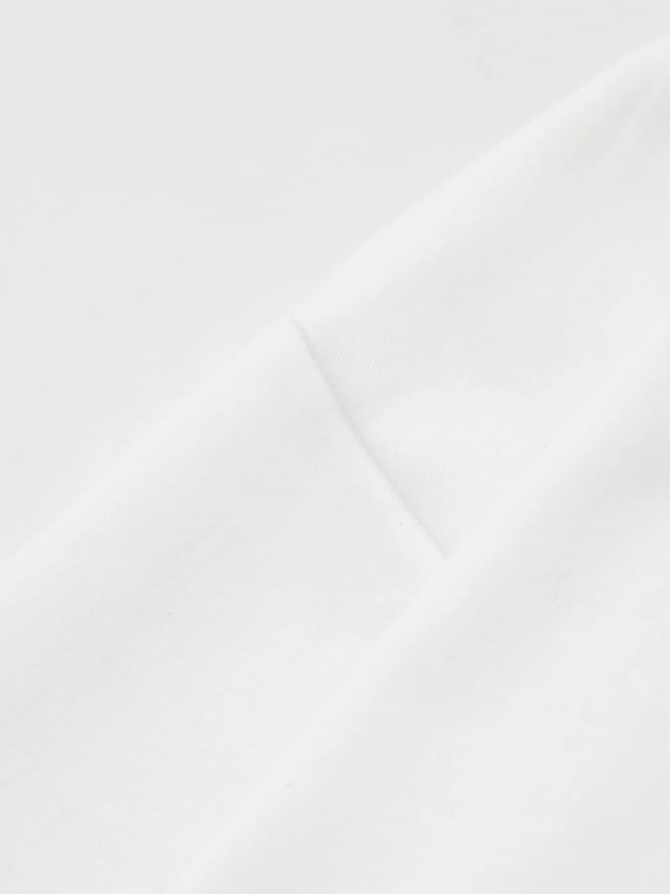 Close-up of a white fabric, possibly a hoodie, showing a seam.