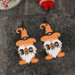 A pair of wooden dwarf earrings with orange hats, white beards, and "BOO" with a pumpkin.