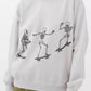 An oversized sweatshirt with three skateboarding skeletons.