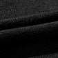 Close-up of black knit fabric with visible texture and folds.