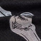 Close-up of black jeans with white skeleton embroidery on the thigh.