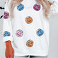 White sweatshirt with colorful sequin pumpkin lantern patches.