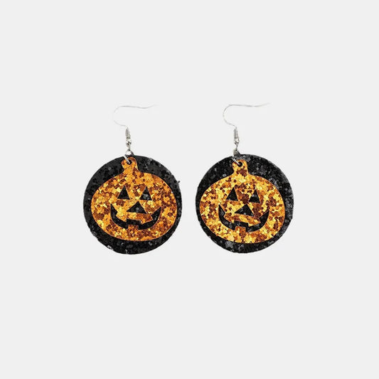 Two glittery black and orange pumpkin-shaped dangle earrings are displayed.