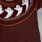 A maroon long-sleeve sweater with white ghost patterns and colorful trim.