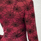 A sheer, long-sleeve blouse in red with a black spider web print.