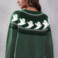 A woman models a green long-sleeve sweater with a white ghost pattern.