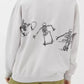 An oversized light grey sweatshirt with a black skeleton graphic skateboarding on the back.