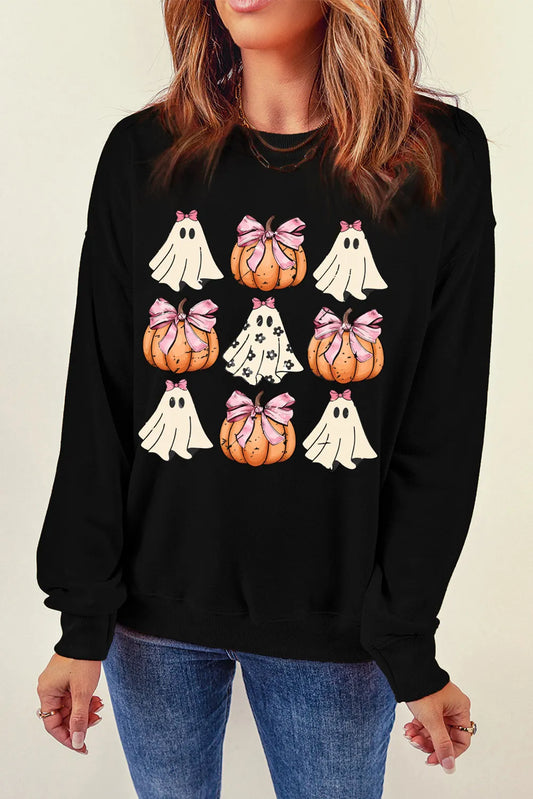 A woman wears a black long-sleeve sweatshirt with a pumpkin and ghost pattern.