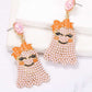 Smiling ghost shape synthetic pearl earrings with orange bows.
