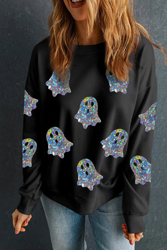 A woman wears a black long-sleeve sweatshirt with holographic ghost patterns and blue jeans.
