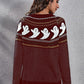 A woman models a maroon long-sleeve sweater with a ghost pattern.