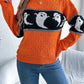 Orange long-sleeve sweater with a black and white ghost pattern.
