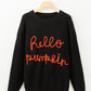 Black long-sleeve sweater with "hello pumpkin" embroidered in orange.