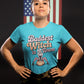 A woman wears a blue t-shirt with "Baddest Witch in Town" and a witch on a pumpkin.