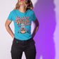 A woman wears a blue t-shirt with "Baddest Witch in Town" and a witch on a pumpkin.