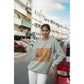 A woman wears a light gray "Witch Way to the Candy" Halloween sweatshirt.