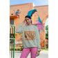 A woman wears a light gray "Witch Way to the Candy?" Halloween sweatshirt.