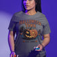 A woman wears a gray Halloween Town t-shirt with a vintage pumpkin graphic.
