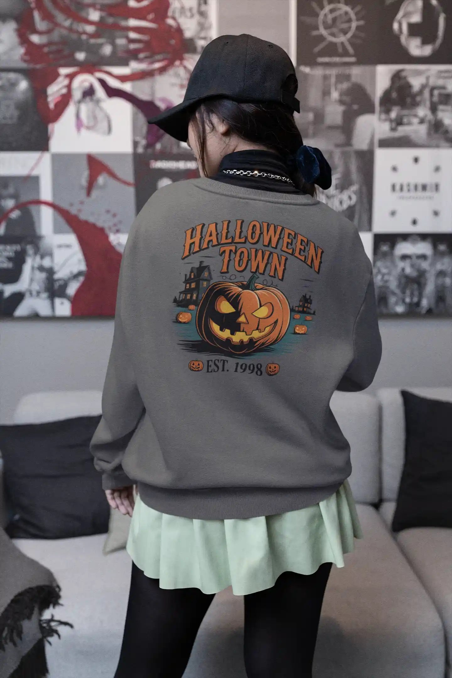 A person from behind wears a gray Halloween Town sweatshirt with a pumpkin graphic.