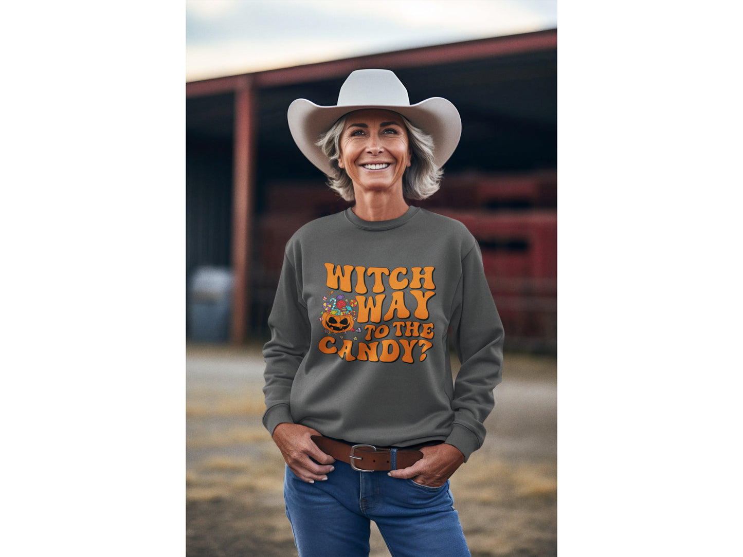 A woman in a cowboy hat smiles, wearing a dark gray "Witch Way to the Candy" sweatshirt.