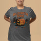A woman wears a dark gray Halloween Town t-shirt with a pumpkin graphic.