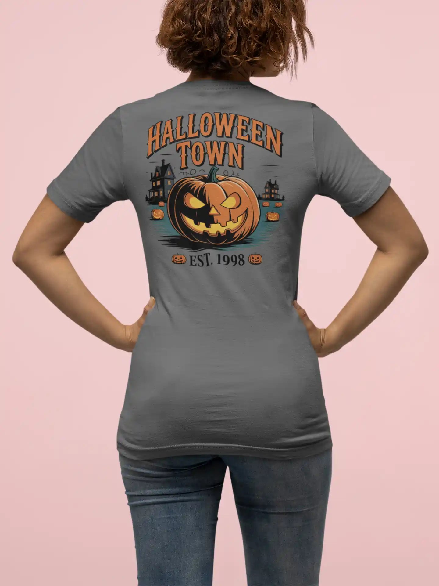 A person from behind wears a gray Halloween Town t-shirt with a pumpkin graphic.