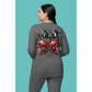 A woman from behind wears a gray long-sleeve shirt with a spooky cherry and bow design.
