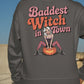 A person from behind wears a dark gray sweatshirt with "Baddest Witch in Town" text.