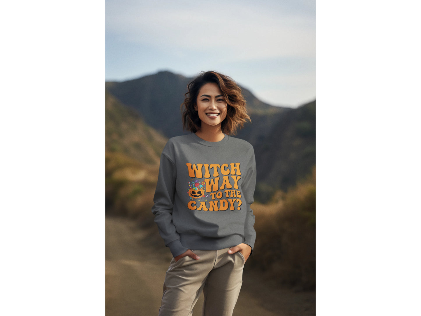 A woman wears a dark gray "Witch Way to the Candy?" Halloween sweatshirt.