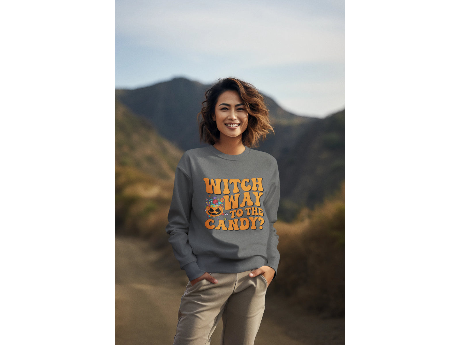 A woman wears a dark gray "Witch Way to the Candy?" Halloween sweatshirt.
