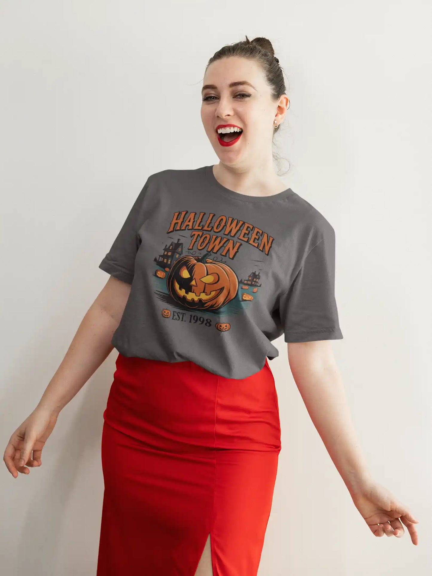 A woman in a gray Halloween Town t-shirt and red skirt smiles at the camera.