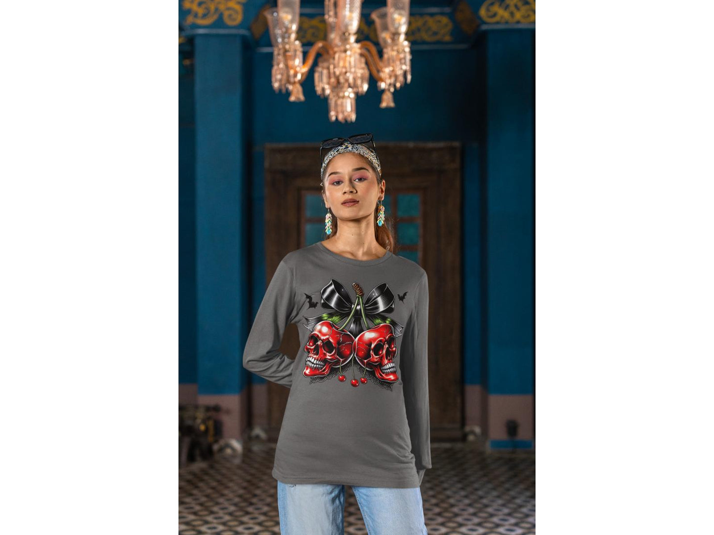 A woman wears a gray long-sleeve shirt with a spooky cherry and bow design.