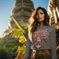 A woman wears a grey sweatshirt with "Baddest Witch in Town" and a witch on a pumpkin.