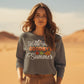 A woman in a desert wears a gray sweatshirt with "Hello Fall GOODBYE Summer" text.