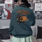 A person from behind wears a dark green Halloween Town sweatshirt with a pumpkin graphic.