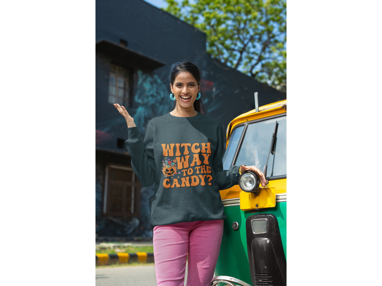 A woman wears a dark gray "Witch Way to the Candy" Halloween sweatshirt.