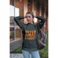 A woman wears a dark grey sweatshirt with "Witch Way to the Candy?" in orange text.