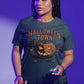 A woman wears a dark green Halloween Town t-shirt with a vintage pumpkin graphic.