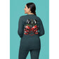 A woman from behind wears a dark green sweatshirt with a spooky cherry and bow design.