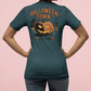 A woman from behind wears a dark teal Halloween Town t-shirt with a pumpkin graphic.