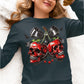 A woman wears a dark long-sleeve shirt with a spooky cherry and skull design.