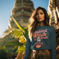 A woman wears a teal sweatshirt with "Baddest Witch in Town" and a witch graphic.