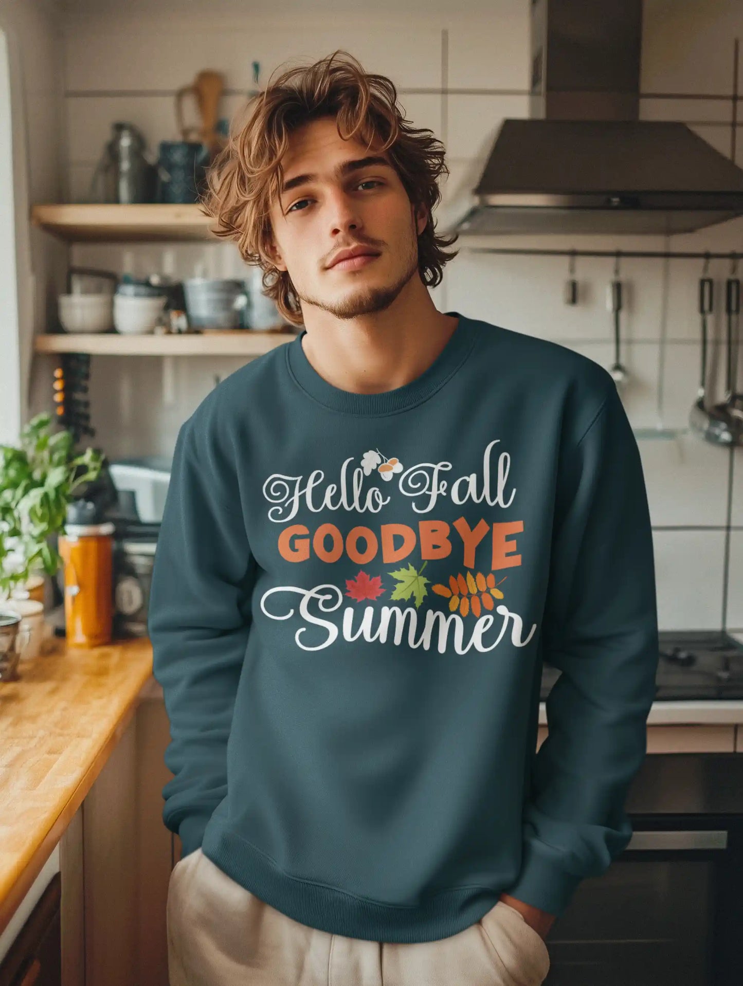 A man wears a dark teal "Hello Fall GOODBYE Summer" sweatshirt with autumn leaves.