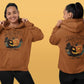 A woman models a brown Halloween Town hoodie with a vintage pumpkin graphic.