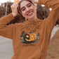 A woman wears a brown Halloween Town hoodie with a vintage pumpkin graphic.
