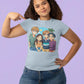 A woman points to her light blue t-shirt featuring four anime characters on a beach.