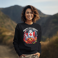 A woman smiles wearing a black sweatshirt with a Canadian Halloween ghost and pumpkin design.